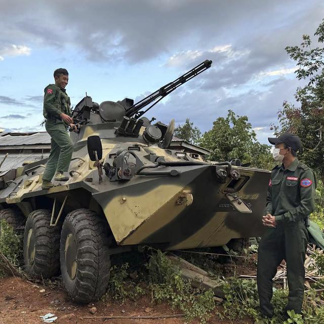 Des membres d'un groupe de forces armées ethniques, l'une des trois milices de l’Alliance de la fraternité, vérifient un véhicule blindé de l'armée que le groupe aurait saisi dans l'État de Shan, en Birmanie, le 24 novembre 2023. [Keystone - The Kokang online media via AP]