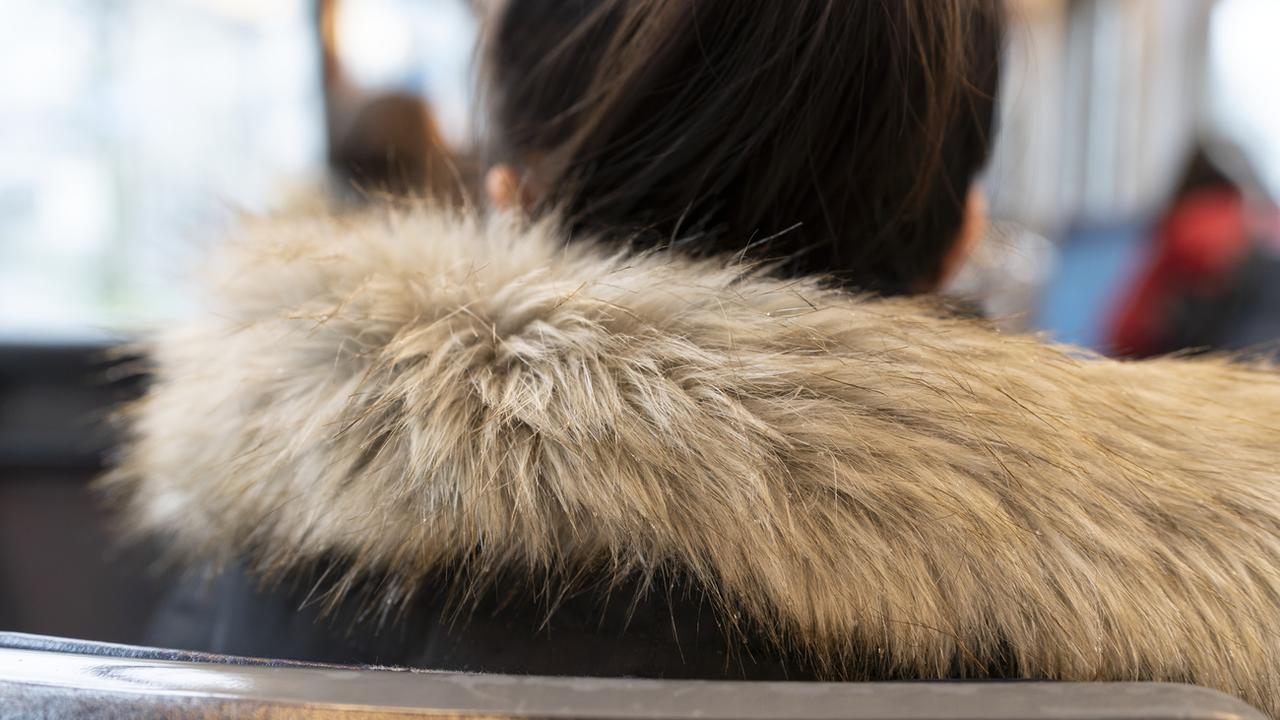 Une femme porte une veste d'hiver avec un col en fourrure à Zurich. [Keystone - Gaetan Bally]