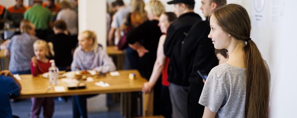 Des jeunes réfugiées et réfugiés venus d'Ukraine attendent de pouvoir prendre un repas à la cafétéria de l'EVAM, en 2022 à Gland (image d'illustration). [Keystone - Valentin Flauraud]