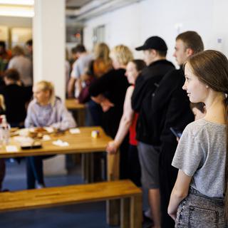 Des jeunes réfugiées et réfugiés venus d'Ukraine attendent de pouvoir prendre un repas à la cafétéria de l'EVAM, en 2022 à Gland (image d'illustration). [Keystone - Valentin Flauraud]