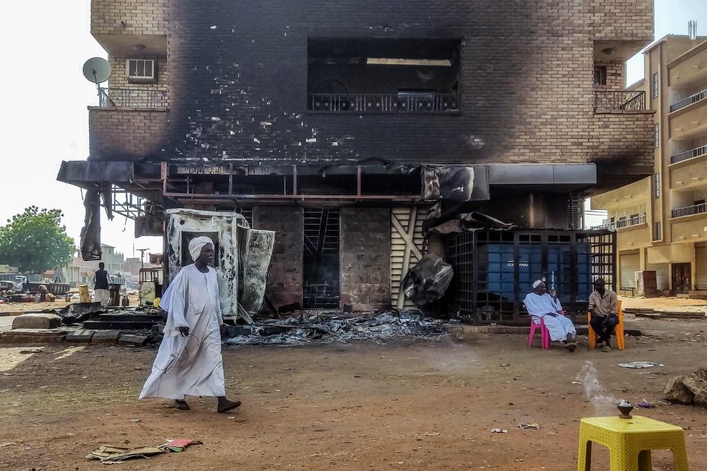 Un homme marche devant une banque bombardée dans le sud de Khartoum. [afp]