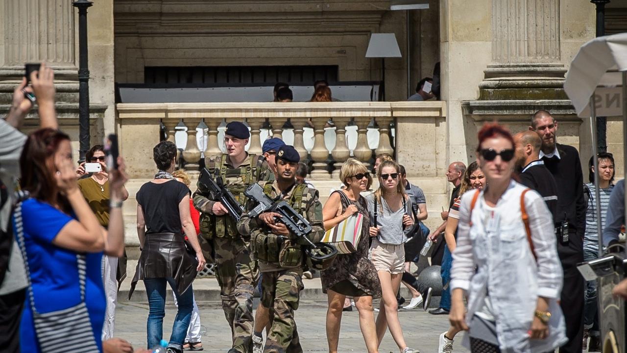 Des soldats patrouillent devant le Louvre à Paris le lendemain de l'attentat de Nice du 14 juillet 2016. [EPA - Christophe Petit Tesson]