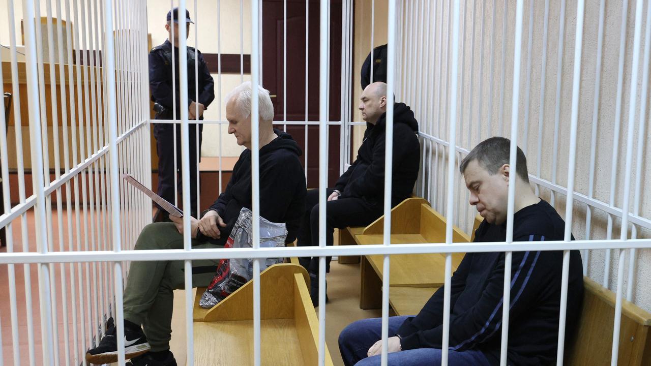 Ales Bialiatski (à l'avant) et ses deux associés jugés avec lui, à l'ouverture de son procès à Minsk. [AFP - Vitaly Pivovarchik]
