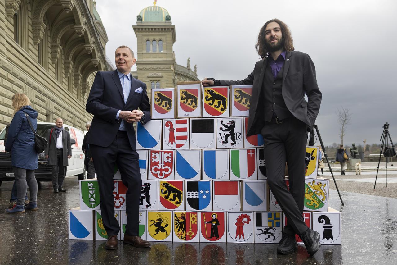 Nicolas Rimoldi (à droite), président de "Mass Voll" et Roland Buehlmann, coprésident des "Amis de la Constitution", lors du dépôt des signatures. [Keystone - Peter Klaunzer]