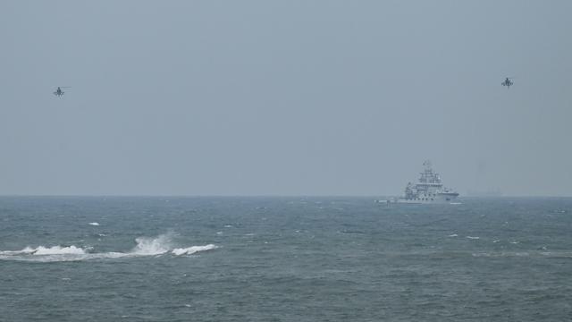 Deux hélicoptères chinois volent prêt de l'île Pingtan, en avril 2023 (archive). [AFP - Greg Baker]