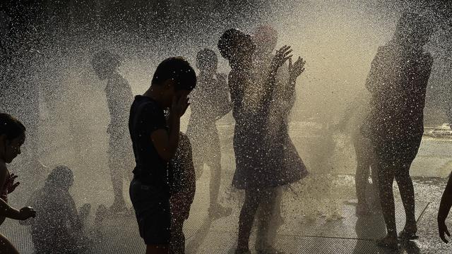 Des enfants jouant dans une fontaine à eau, au nord de l'Espagne à Pampelune. [Keystone/AP Photo - Alvaro Barrientos]