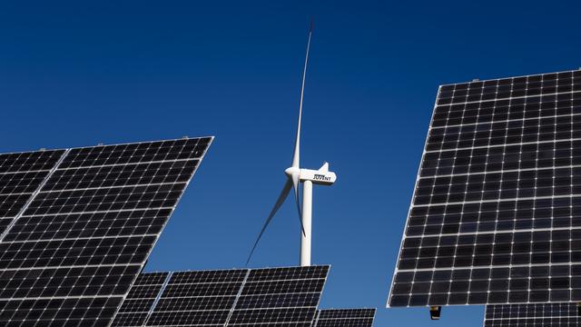 Une éolienne et des panneaux solaires au Mont-Soleil, au-dessus de Saint-Imier (BE). [Keystone - Valentin Flauraud]