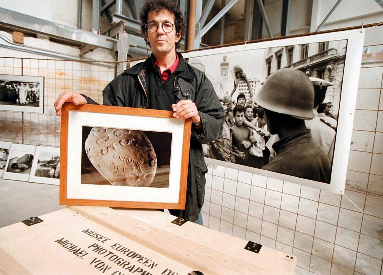 Le photographe bernois Michael von Graffenried avec sa photo de la pierre volée. [Keystone - Roger Meier]