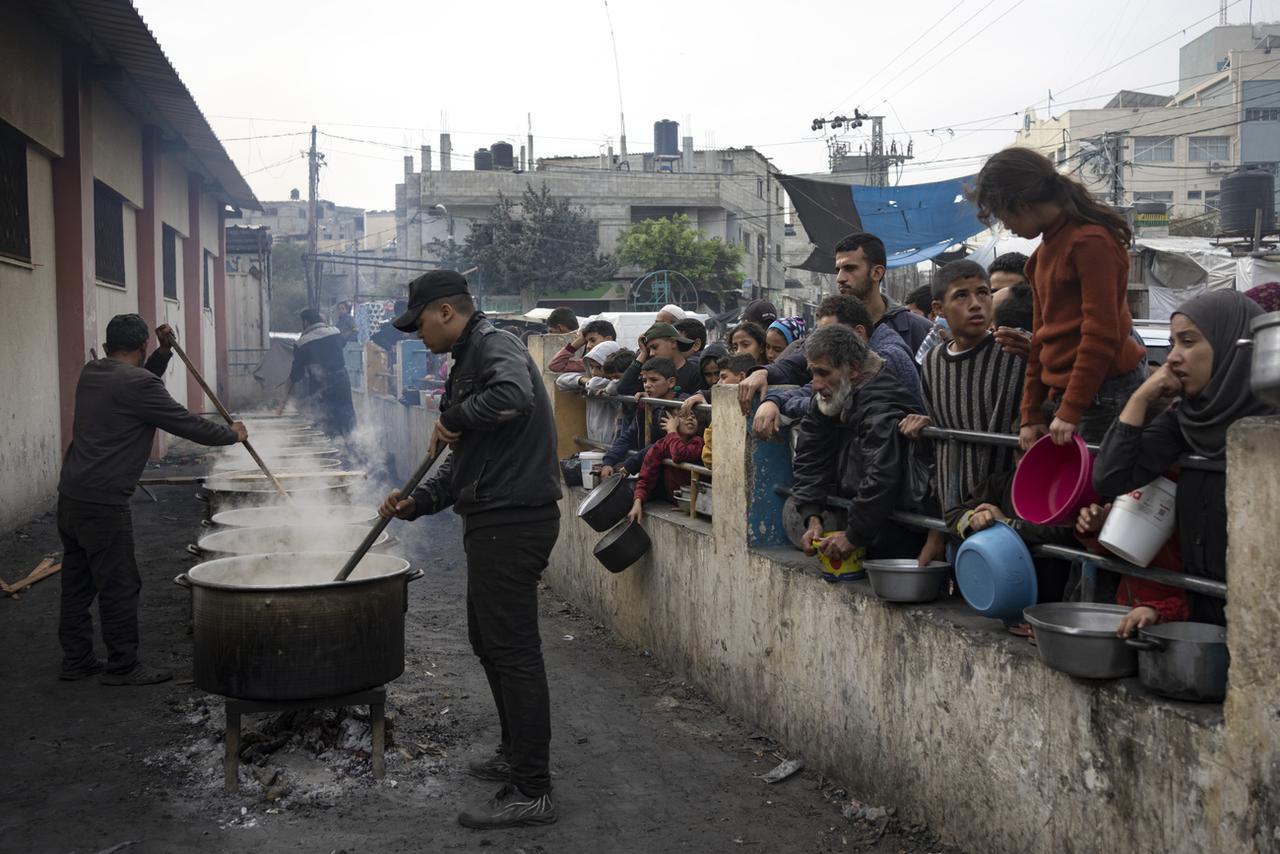 Des Palestiniens attendent la distribution de nourriture à Rafah, dans la bande de Gaza. [AP/Keystone - Fatima Shbair]