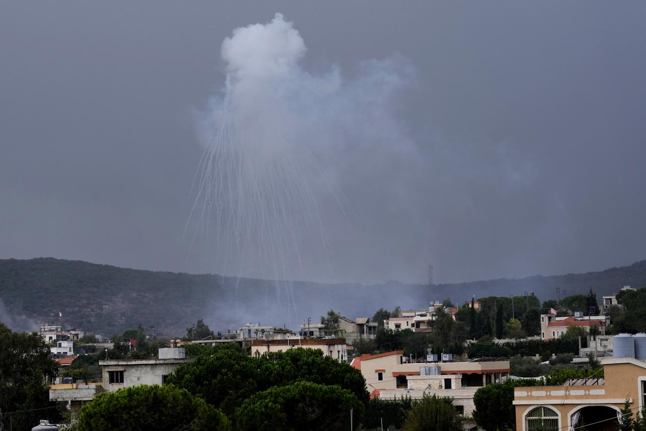Un obus de l'artillerie israélienne explose au-dessus d'Aita al-Shaab, un village libanais frontalier avec Israël, au sud du Liban. [Keystone - AP Photo/Hussein Malla]