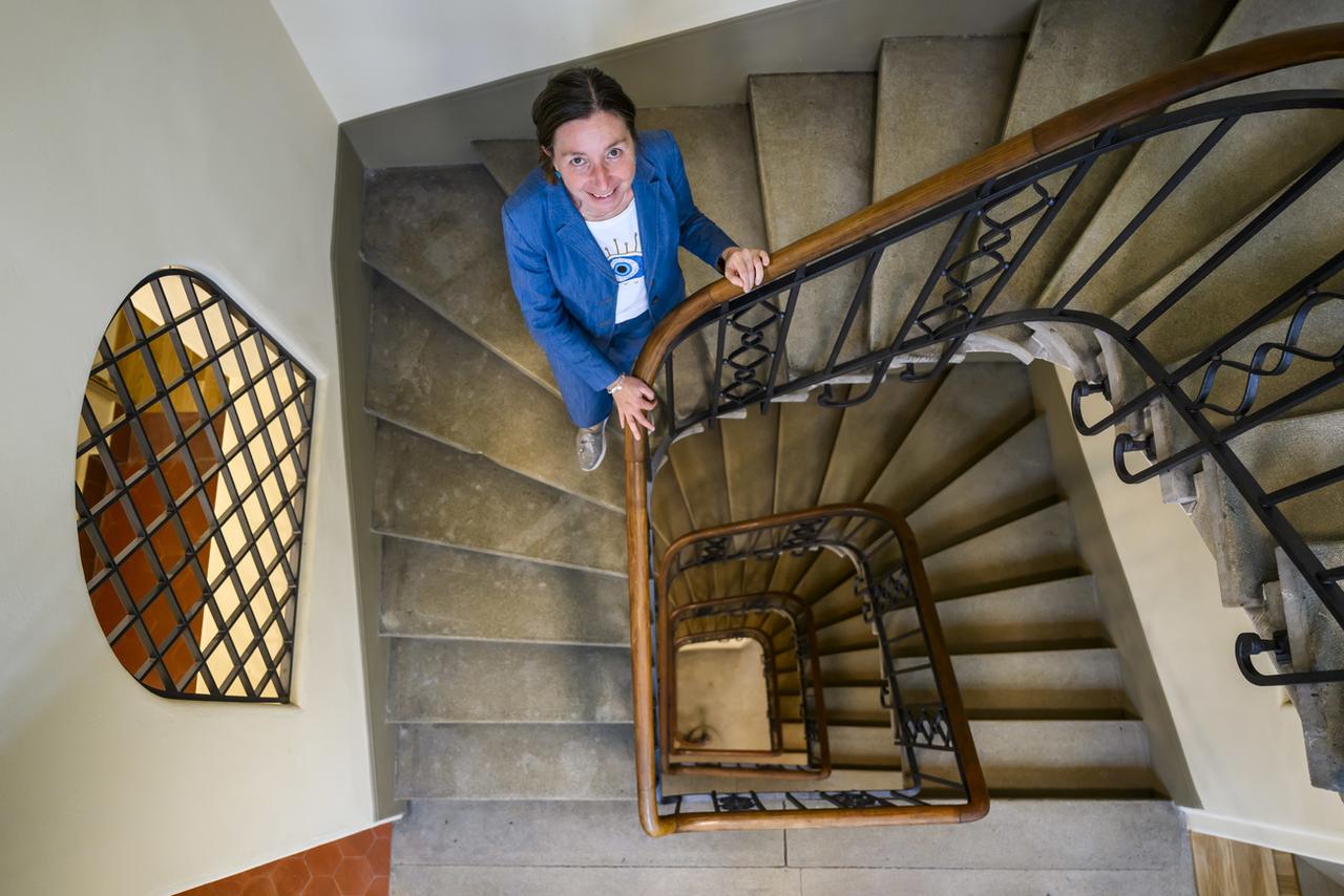 Natacha Litzistorf pose dans un escalier lors d'une conférence de presse sur l'assainissement énergétique des bâtiments de la commune de Lausanne. [Keystone - Jean-Christophe Bott]