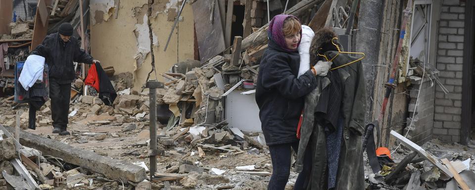 Une résidente ukrainienne quitte la ville de Zaporizhzhya après une attaque de missiles russes le dimanche 1 janvier 2023. [Keystone - Andriy Andriyenko/AP Photo]