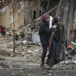 Une résidente ukrainienne quitte la ville de Zaporizhzhya après une attaque de missiles russes le dimanche 1 janvier 2023. [Keystone - Andriy Andriyenko/AP Photo]