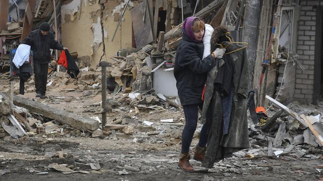 Une résidente ukrainienne quitte la ville de Zaporizhzhya après une attaque de missiles russes le dimanche 1 janvier 2023. [Keystone - Andriy Andriyenko/AP Photo]