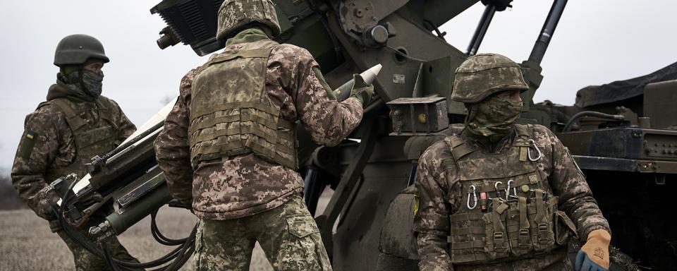 Des soldats ukrainiens à la manoeuvre autour d'un canon français Caesar dans la région de Donetsk. [Keystone - Libkos]