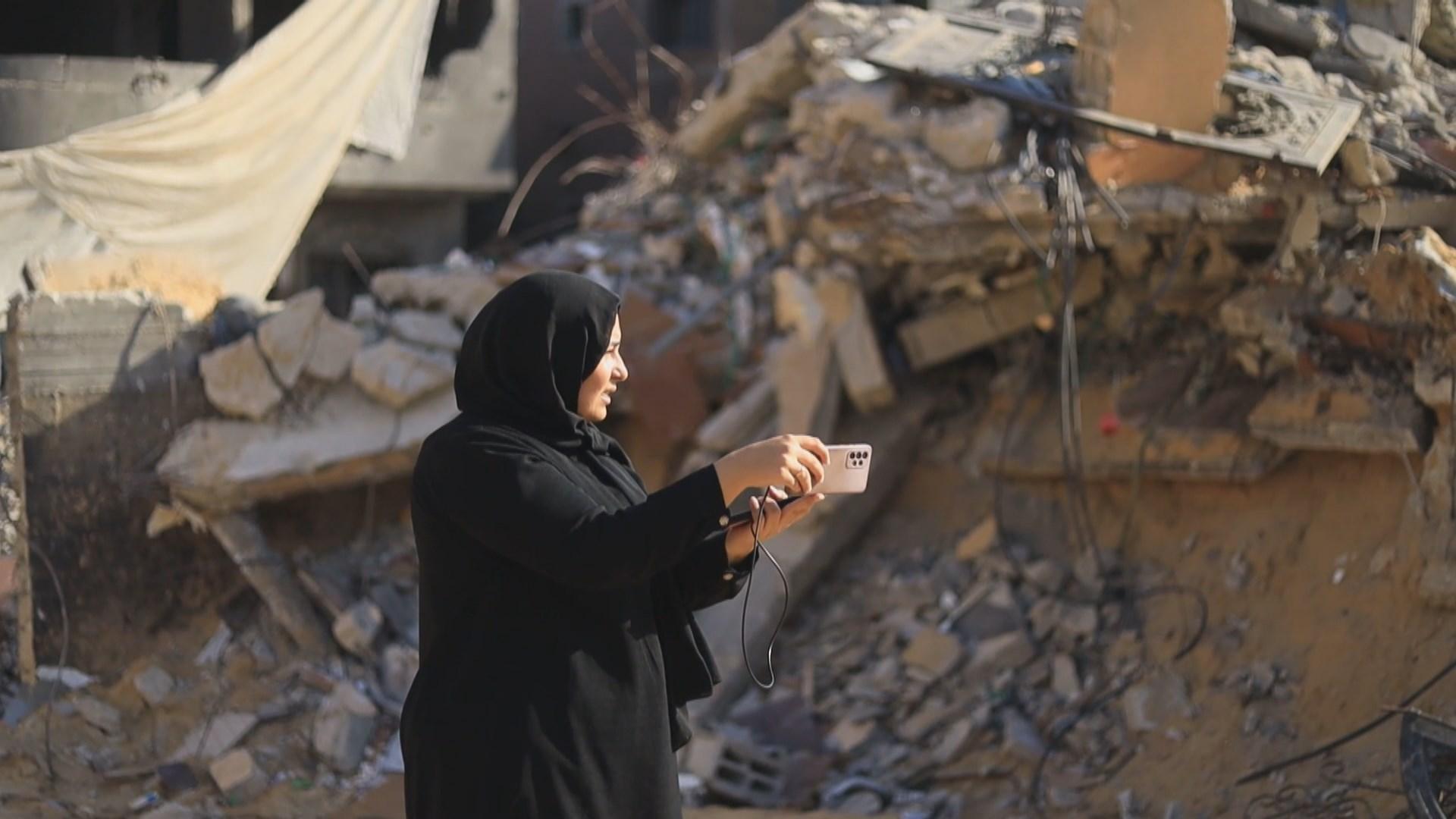 Heba, devant la maison en ruine d'amis de sa famille, témoigne de son quotidien à Gaza. [RTS]