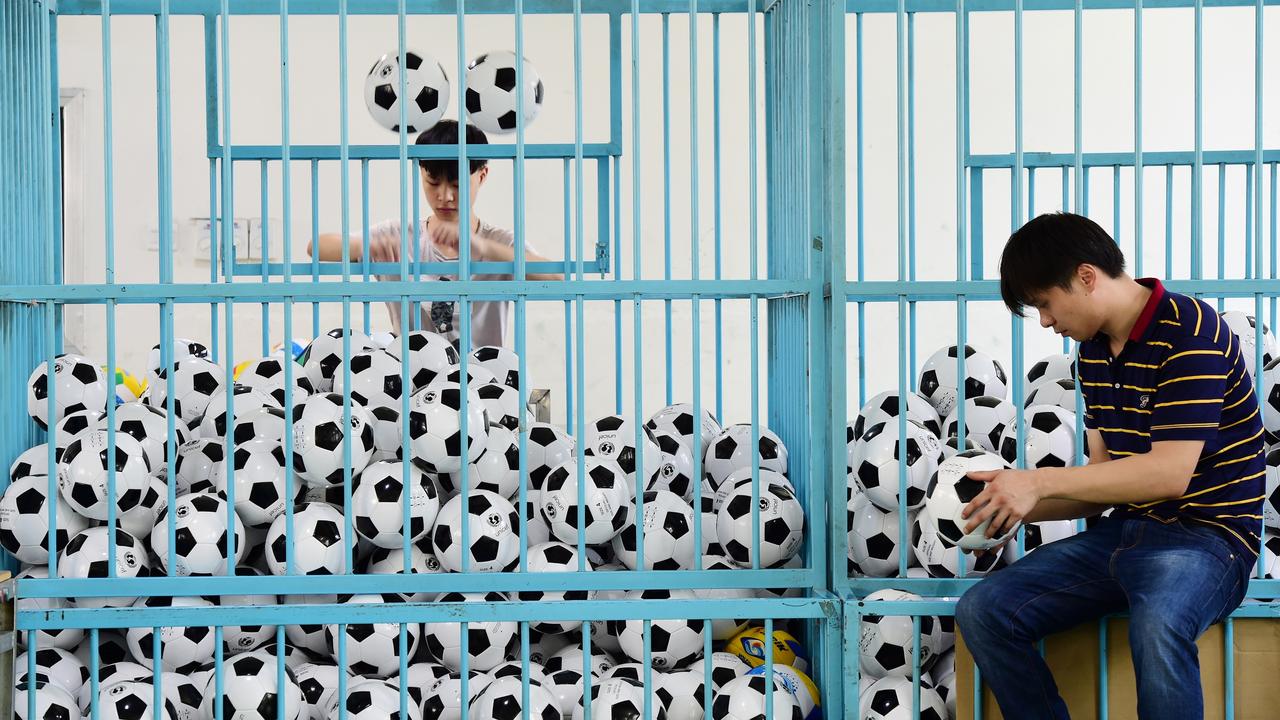 Des employés trient des ballons de football dans une entreprise fabriquant des équipements sportifs, à Yiwu. [reuters]