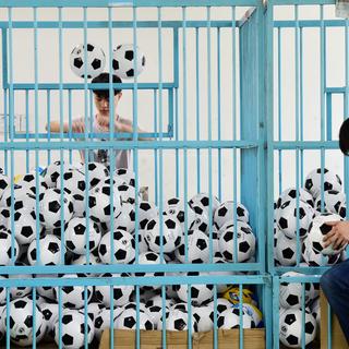 Des employés trient des ballons de football dans une entreprise fabriquant des équipements sportifs, à Yiwu. [reuters]