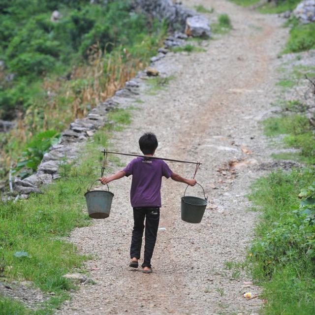 Un petit garçon rapporte de l'eau dans son village. [AFP - HUANG XIAOBANG / XINHUA]