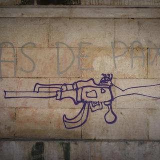 Un graffiti représente le dessin d'une kalachnikov sur un mur de Marseille, avec l'inscription pas de paix. [AFP - Justine Bonnery / Hans Lucas]