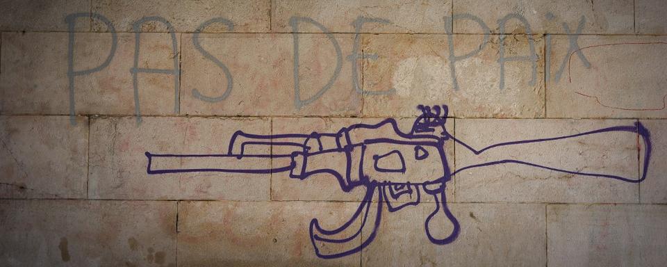 Un graffiti représente le dessin d'une kalachnikov sur un mur de Marseille, avec l'inscription pas de paix. [AFP - Justine Bonnery / Hans Lucas]