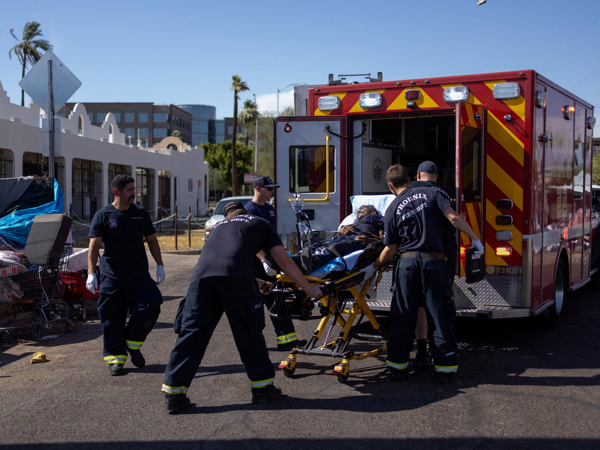 Les ambulanciers du corps des pompiers de Phoenix portent secours à un homme qui s'est effondré en raison de la chaleur extrême qui s'est abattue durant tout le mois de juillet sur la ville. [Reuters - Carlos Barria]