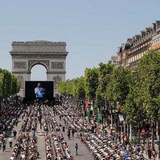 Des personnes participent à "La plus grande dictée du monde" organisée sur les Champs Élysées de Paris, le 4 juin 2023. [Keystone/EPA - Teresa Suarez]
