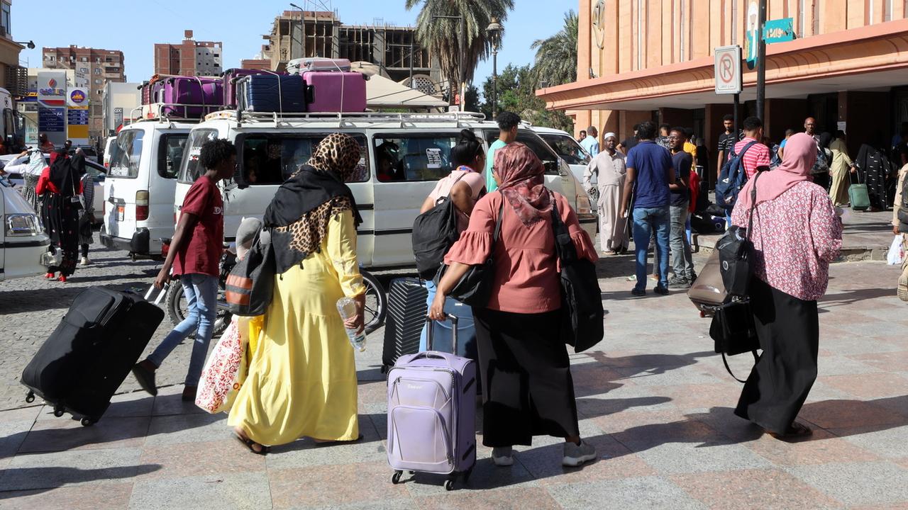 Des personnes ayant fui le Soudan attendent devant la gare d'Assouan, en Égypte, le 4 mai 2023. [KEystone - Khaled Elfiqi]