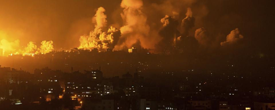 De la fumée et du feu s'échappent de la bande de Gaza après une riposte aérienne de l'armée israélienne, le 8 octobre 2023. [Keystone/AP Photo - Fatima Shbair]