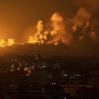 De la fumée et du feu s'échappent de la bande de Gaza après une riposte aérienne de l'armée israélienne, le 8 octobre 2023. [Keystone/AP Photo - Fatima Shbair]