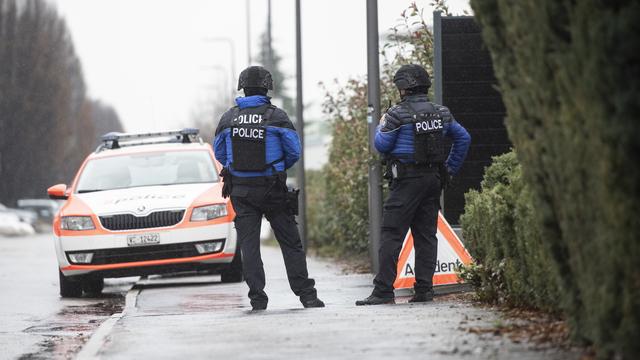 Deux policiers valaisans pendant la chasse à l'homme. [Keystone - EPA/Louis Dasselborne]