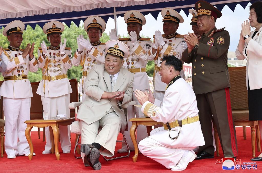 Cette photo diffusée par l'agence de presse nord-coréenne montre Kim Jong Un coiffé d'un couvre-chef de la marine et applaudissant le lancement du nouveau sous-marin. [AFP PHOTO/KCNA VIA KNS - STR]