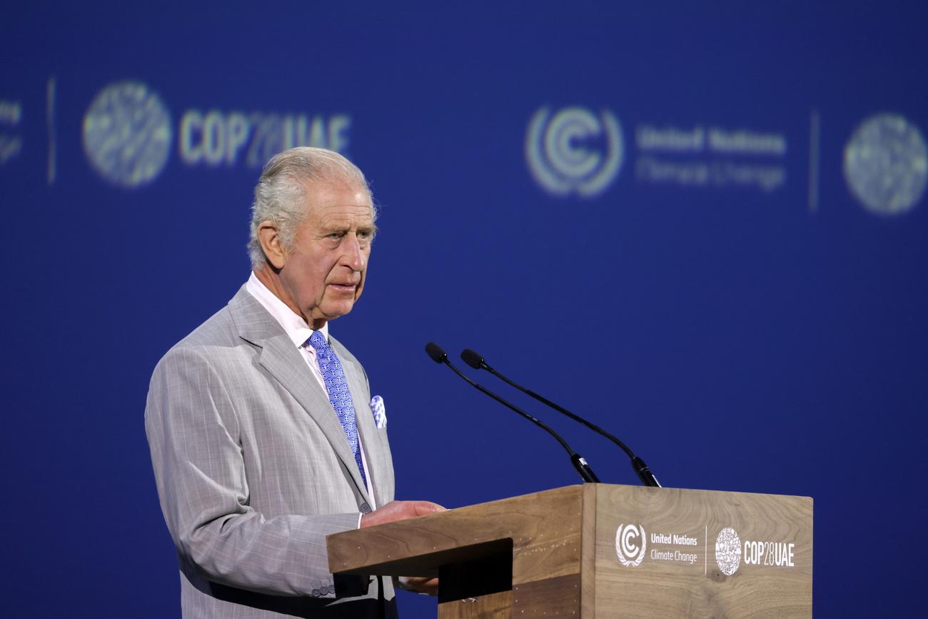 Le roi Charles s'exprimant au pupitre du sommet de la COP28. [EPA/Keystone - Christophe Visieux]