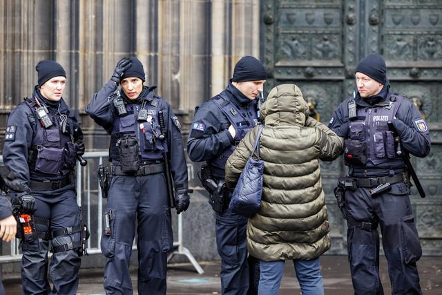 Les fidèles se rendant aux services religieux de Noël à Cologne doivent se soumettre à de stricts contrôles à l'entrée. [Keystone - EPA/Christopher Neuendorf]