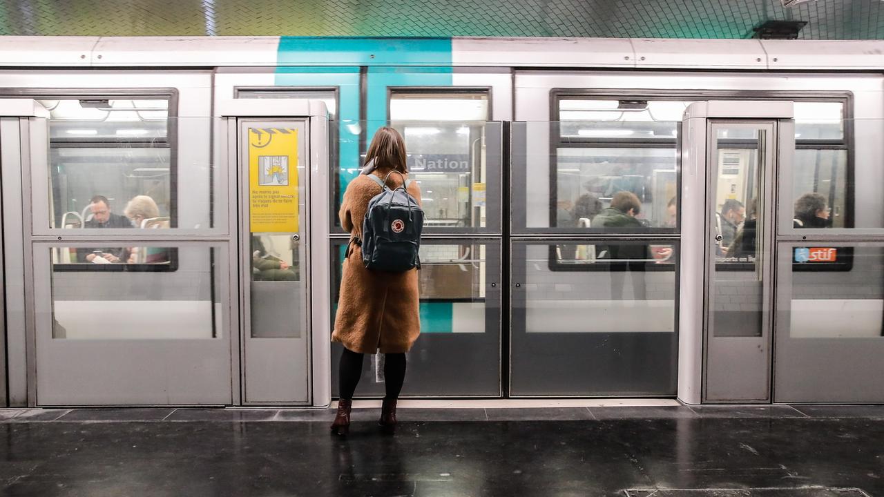 Une femme devant le métro parisien lors d'une perturbation des services ferroviaires, images d'illustration. [Keystone - Teresa Suarez]