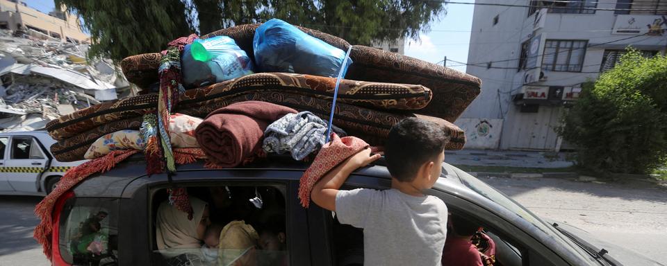 Des Palestiniens fuient leurs maisons en direction de la partie sud de la bande de Gaza après l'appel d'Israël à plus d'un million de civils du nord de Gaza à se déplacer vers le sud dans les 24 heures, le 13 octobre 2023. [REUTERS - AHMED ZAKOT]