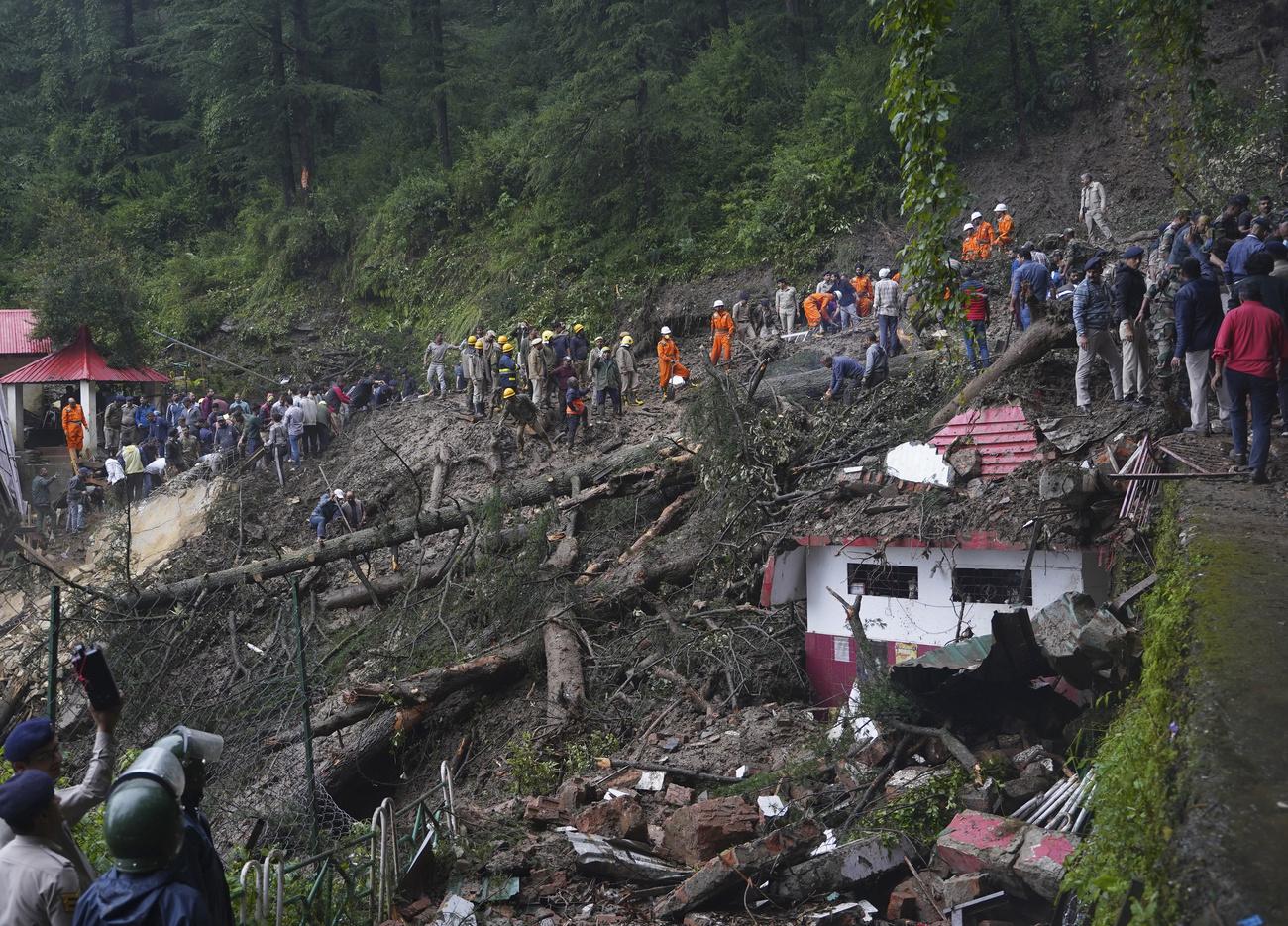 Des sauveteurs recherchent des personnes prises au piège après un glissement de terrain près d'un temple à la périphérie de Shimla, dans l'Etat de l'Himachal Pradesh. [Keystone - Pradeep Kumar / AP Photo]