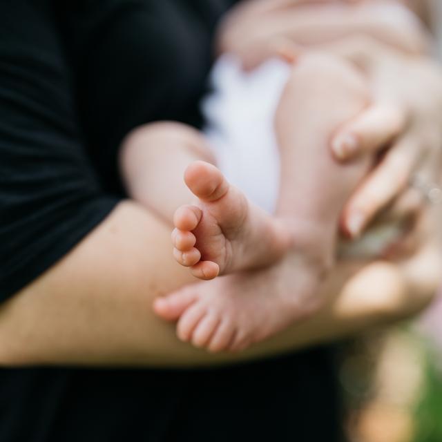 Personne tenant un bébé dans les bras [Unsplash - Wes Hicks]