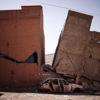 Des bâtiments endommagés et une voiture après un puissant tremblement de terre à Asni, au Maroc, le 11 septembre 2023. [Keystone - Yoan Valat]