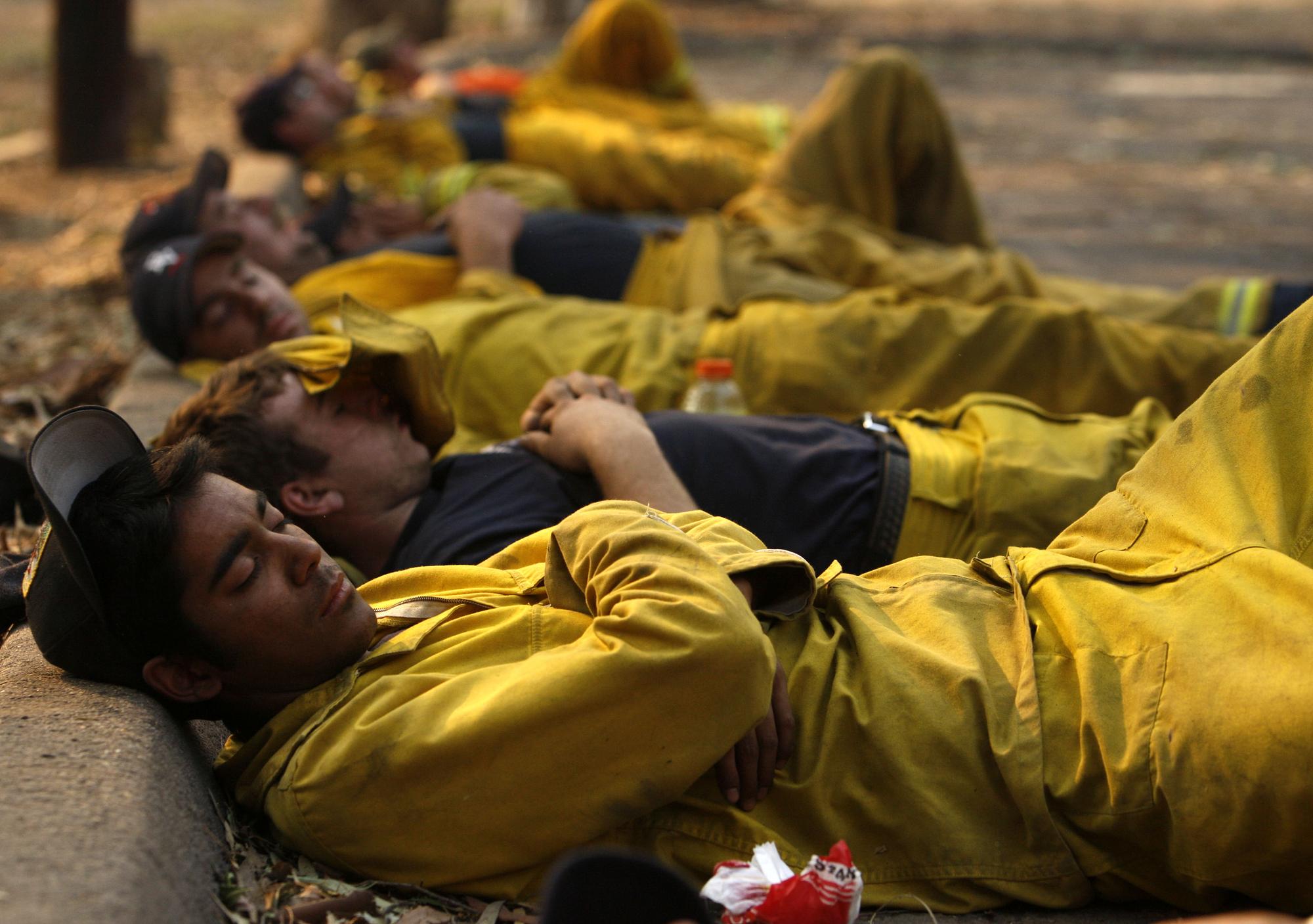 Dans certains métiers, la fatigue est inévitable. Sur cette image de 2007, des pompiers californiens se reposent après avoir combattu sans relâche des incendies dans la région de San Diego. [Reuters - Lucy Nicholson]