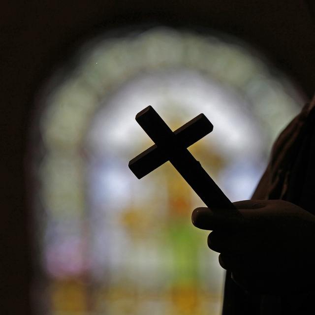 La silhouette d'un crucifix et un vitrail à l'intérieur d'une église catholique de la Nouvelle-Orléans. (image d'illustration) [AP Photo/Keystone - Gerald Herbert]