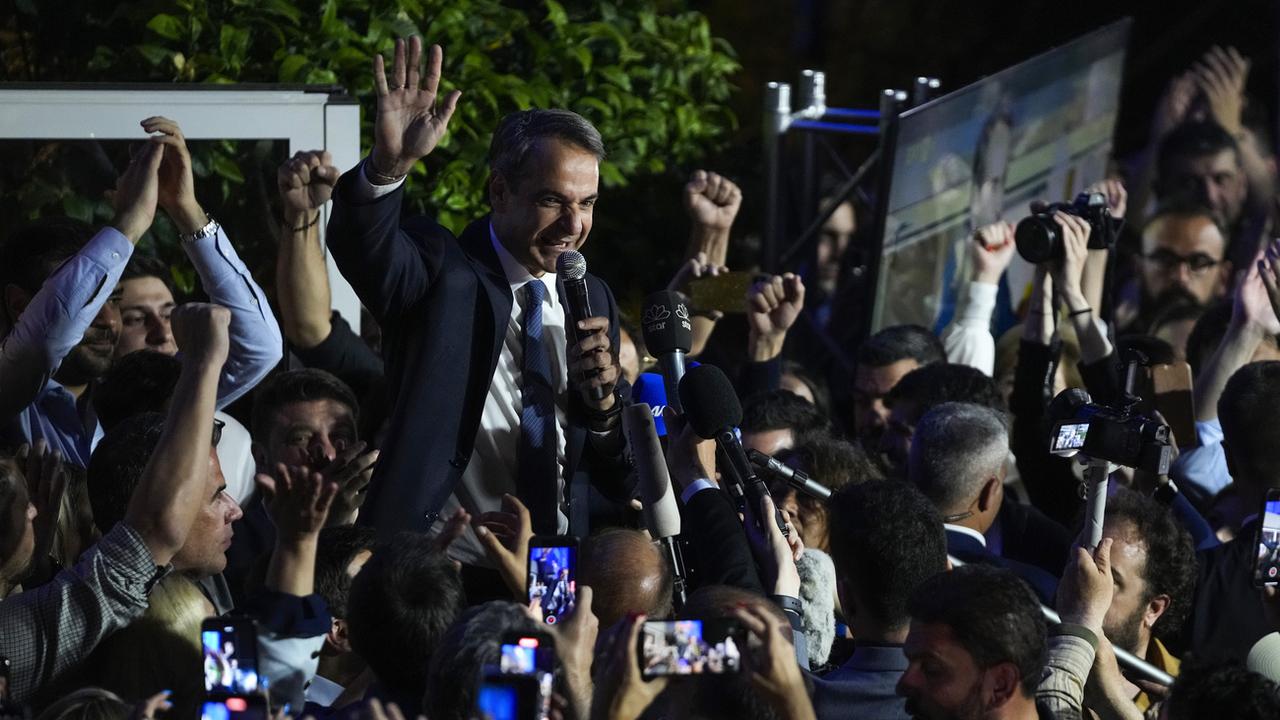 Le Premier ministre grec et leader du parti politique Nouvelle Démocratie, Kyriakos Mitsotakis, salue ses partisans après l'annonce des premiers résultats des élections générales grecques à Athènes le 21 mai 2023. [Keystone - Thanassis Stavrakis]