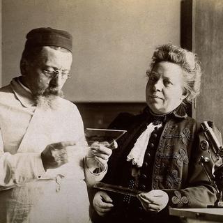 Augusta Klumpke en compagnie de son mari Jules Dejerine en train de regarder des coupes histologiques de cerveau humain. [CC-BY-4.0 - WikiCommons]