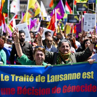 Les membres de la communauté kurde prennent part à une manifestation qui dénonce le Traité de Lausanne, signé il y a 100 ans au Palais de Rumine. [Keystone - Jean-Christophe Bott]