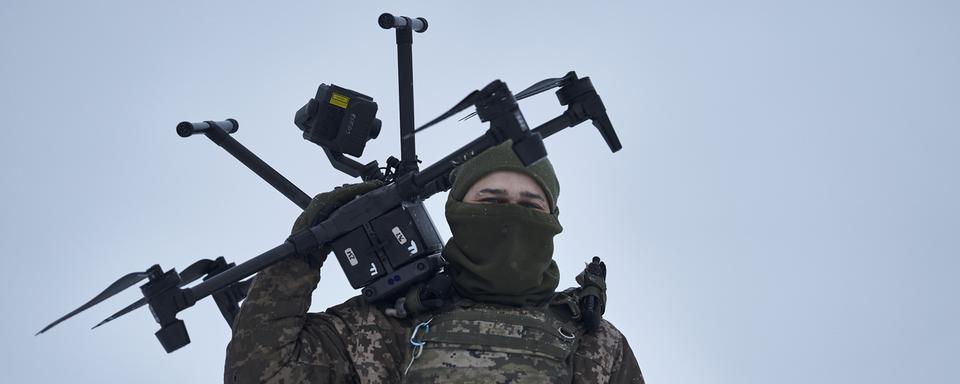 Un soldat ukrainien tranporte un drone près d'Avdiivka, dans la région de Donetsk, le 17 février 2023. [Keystone - AP Photo/Libkos]