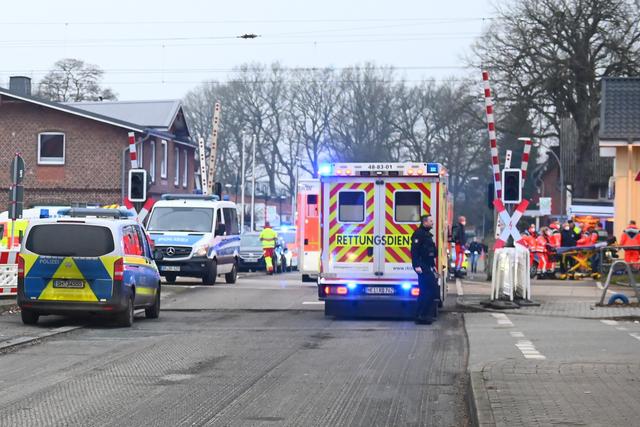 Les forces de police et les services de secours interviennent à un passage à niveau près de la gare de Brokstedt, en Allemagne, où plusieurs personnes ont été blessées et deux tuées, mercredi 25 janvier 2023, lors d'une attaque au couteau dans un train régional reliant Kiel à Hambourg. [KEYSTONE - Jonas Walzberg / DPA]