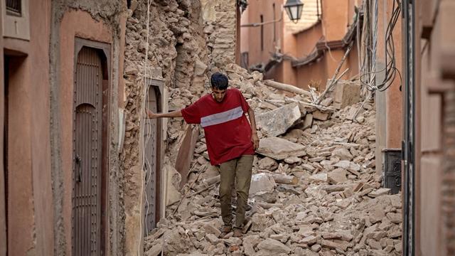 Un habitant se fraye un chemin dans les décombres après un séisme de magnitude 6,8 à Marrakech, le 9 septembre 2023. [AFP - Fadel Senna]