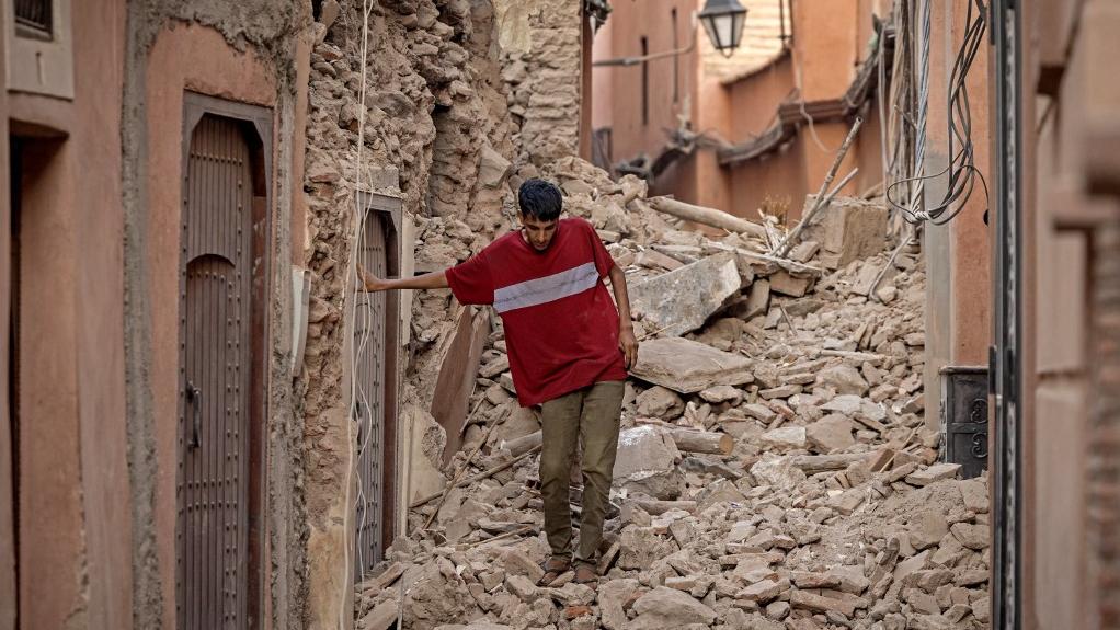 Un habitant se fraye un chemin dans les décombres après un séisme de magnitude 6,8 à Marrakech, le 9 septembre 2023. [AFP - Fadel Senna]