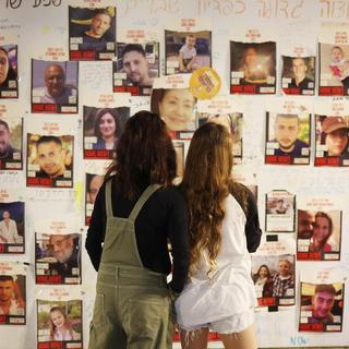 Les portraits des otages sur un panneau à Tel Aviv. [Keystone - EPA/Neil Hall]