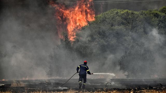 Un pompier luttant contre les gigantesques feux de forêt en Grèce en juillet 2023 (image d'illustration). [Keystone - Vasilis Psomas]